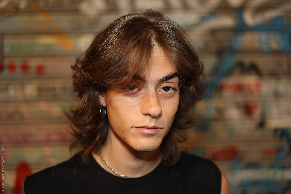 Portrait of long hair man with a rocky style looking at the camera