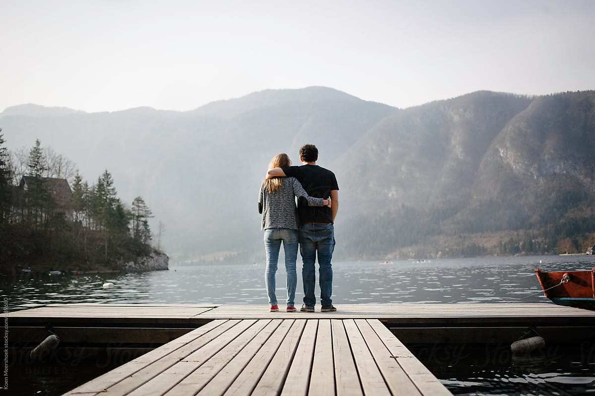 Young couple in love standing arm in arm on a platform