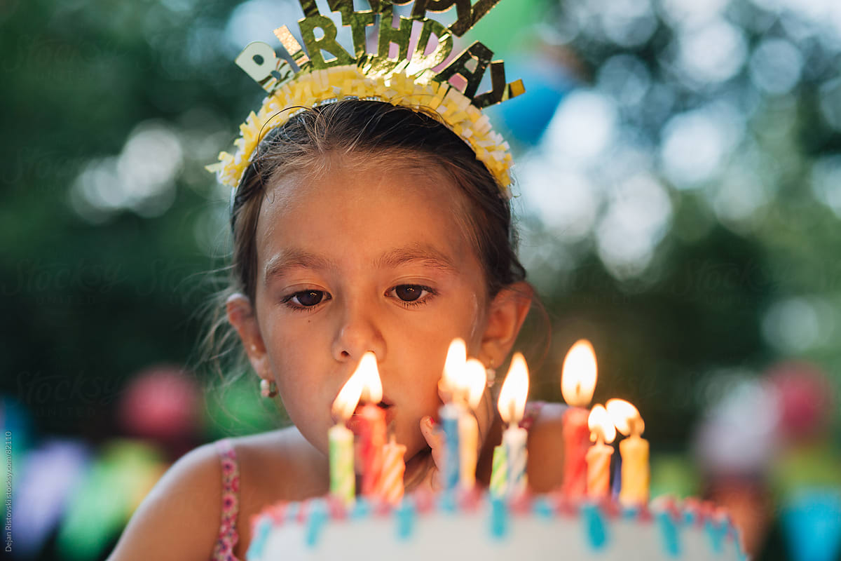 Portrait of a girl blowing candles