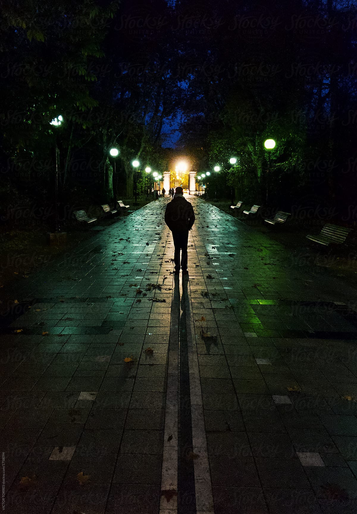 Man Walking Alone Throug A Dark Street At Night | Stocksy ...