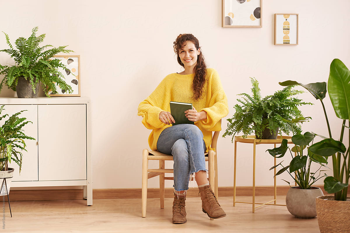 Content woman sitting with book at home