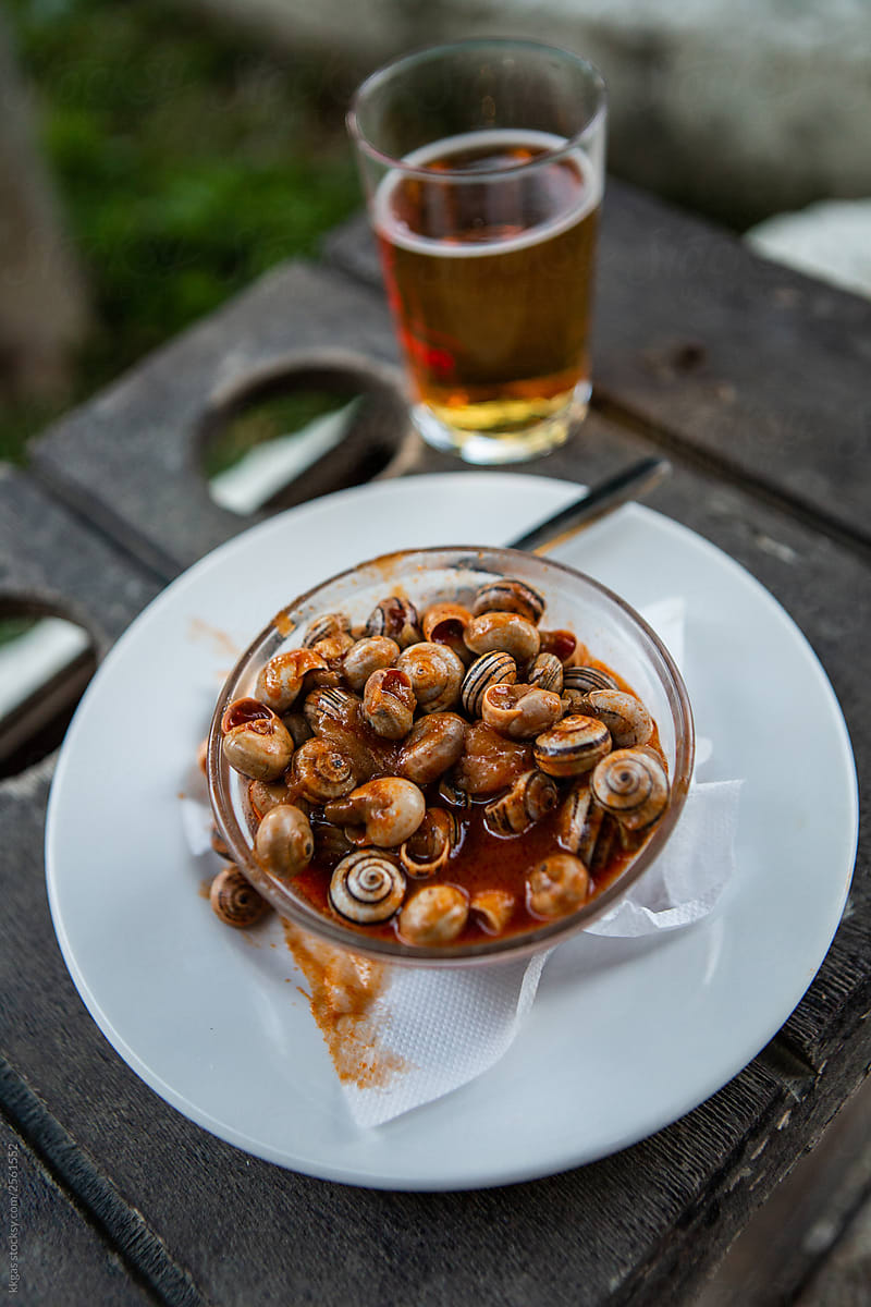 snail tapas served with a small beer