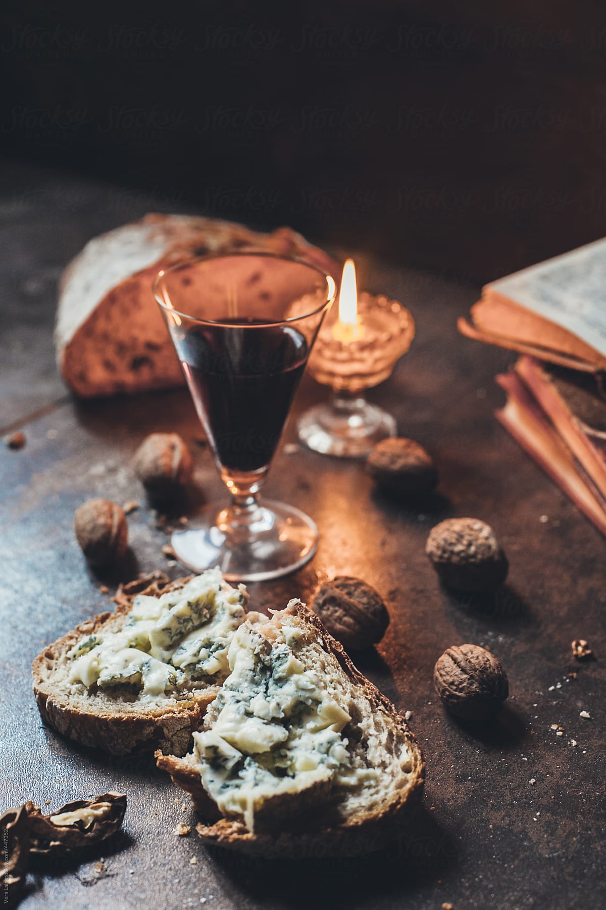 Slice of bread with blue cheese, wine, nuts and candle