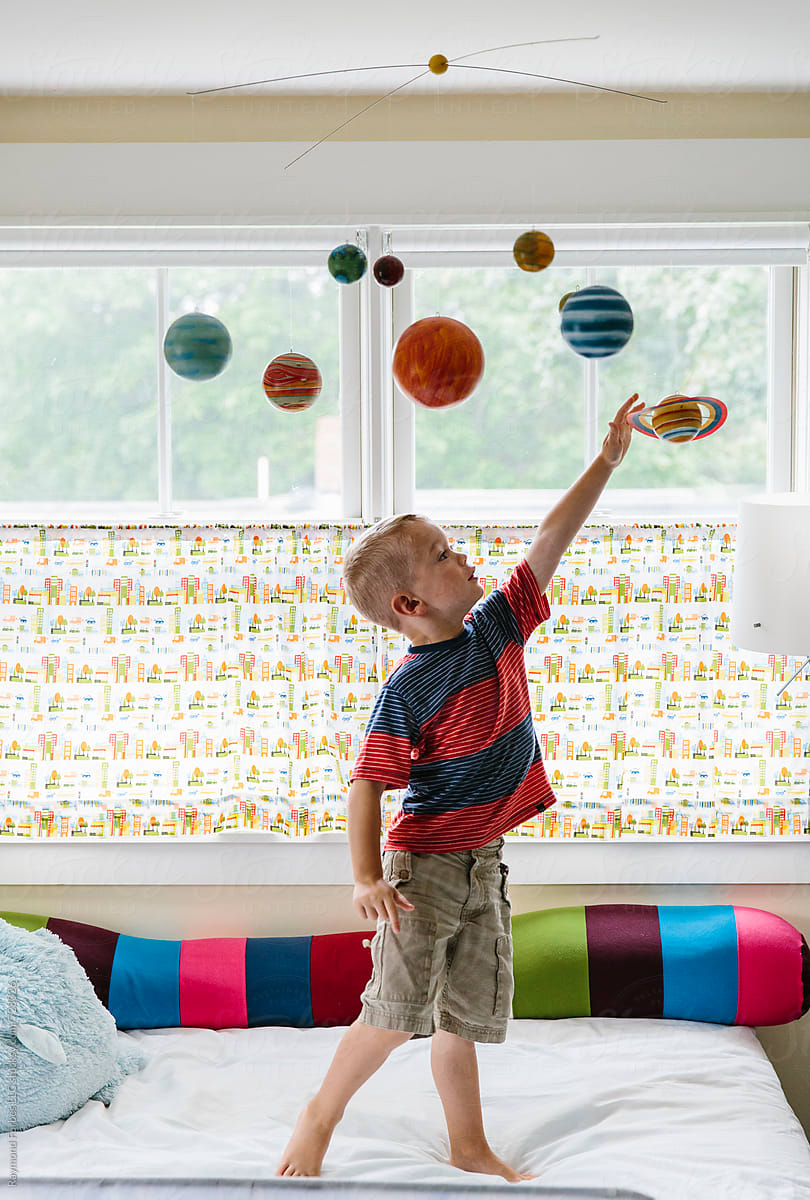 Child Playing with Solar System Mobile