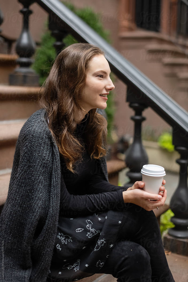 Happy woman with coffee on stoop