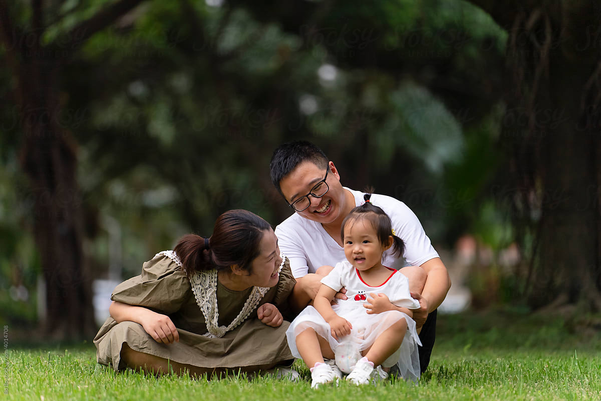 happy asian family with baby in the park