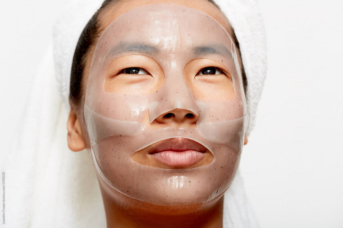 Young asian woman closeup using facial gel mask