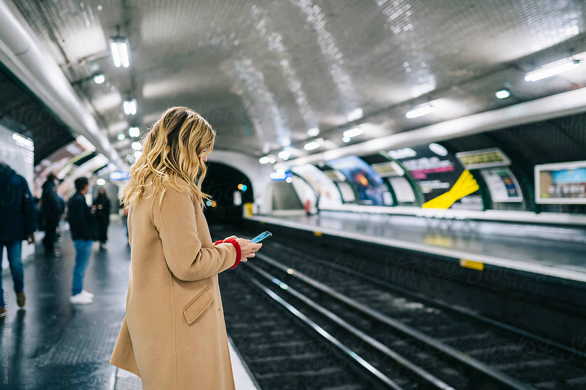 Unrecognizable woman browsing smartphone in metro