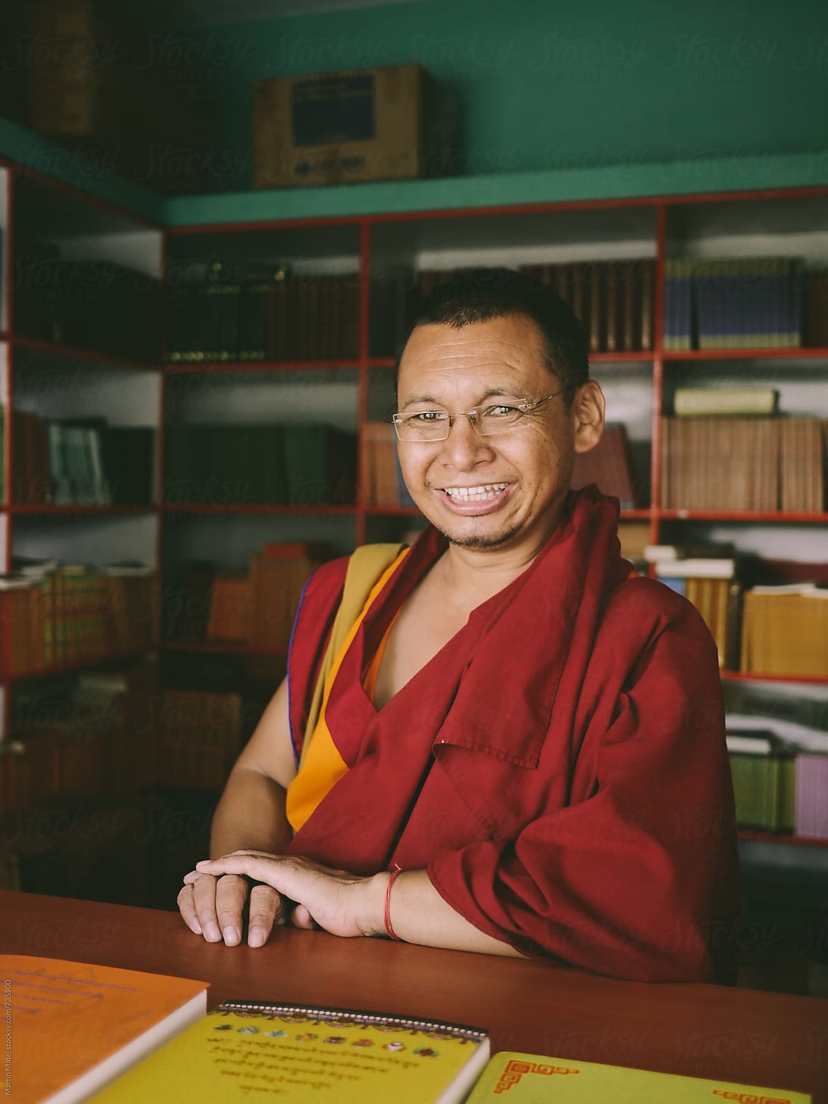Happy Monk Book Seller in front of his Library