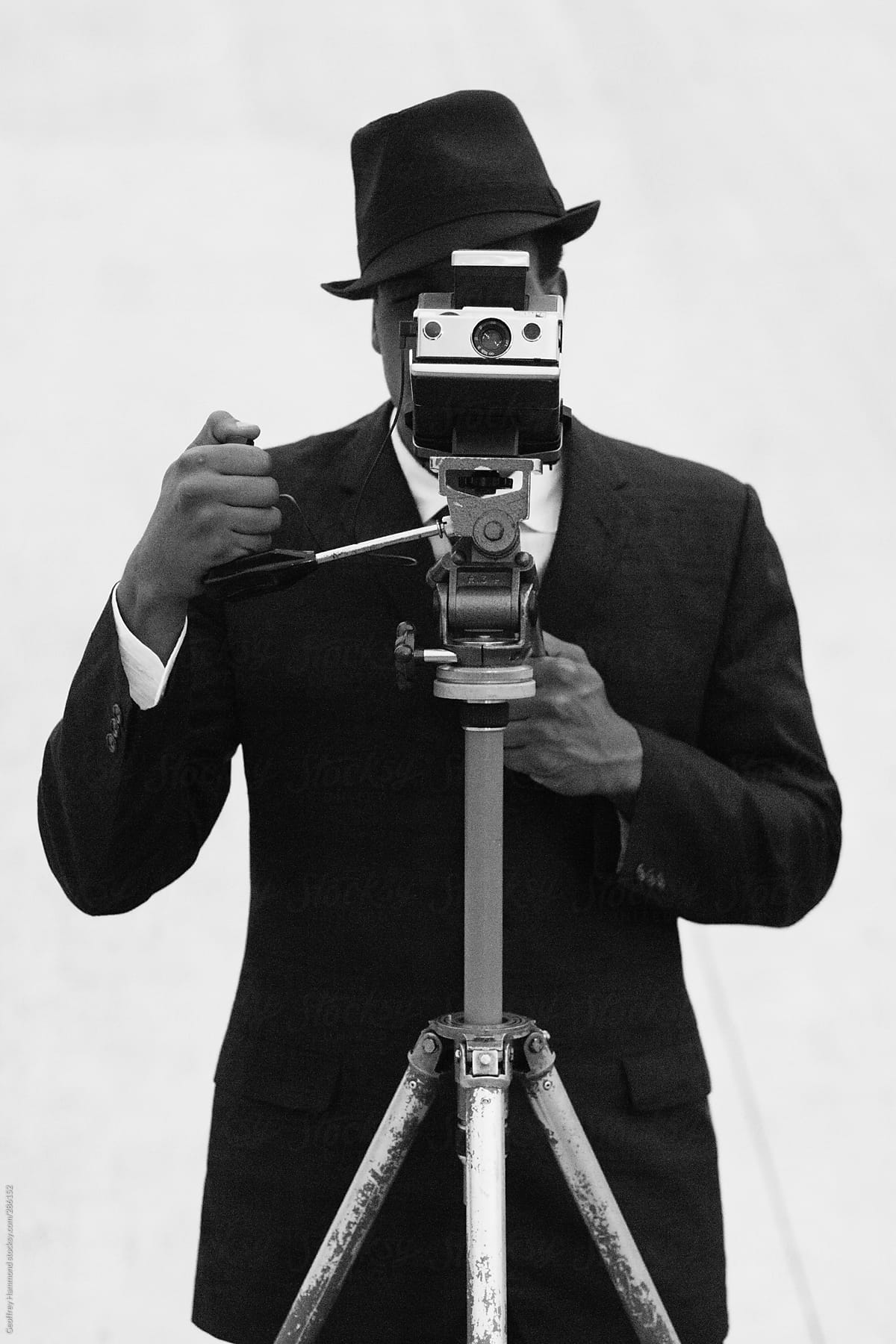 Well-Dressed Man Taking Photograph with Instant Camera