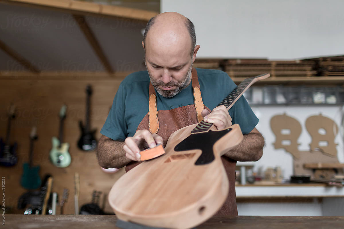 Luthier sanding a guitar