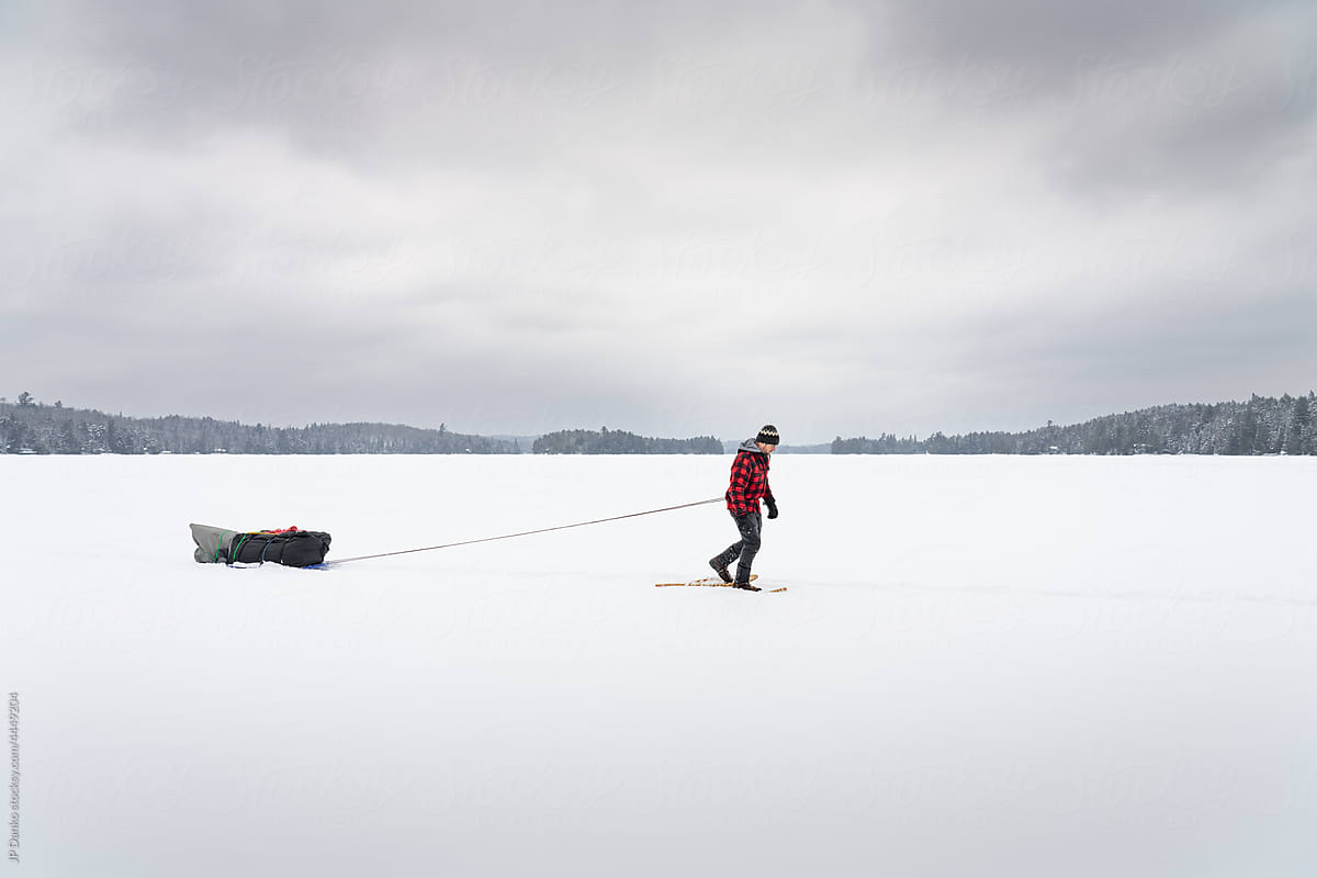Snowshoeing with Heavy Sled Across Frozen Lake