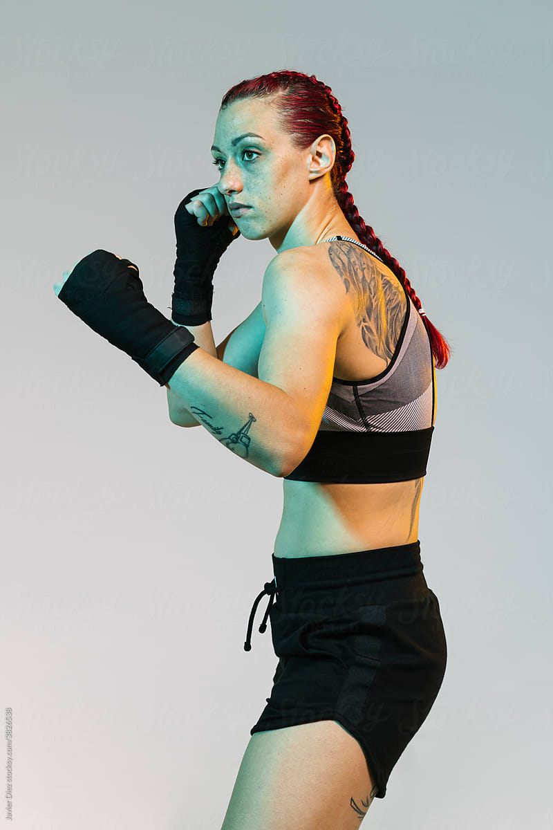 Strong woman in sportswear standing in fighting stance