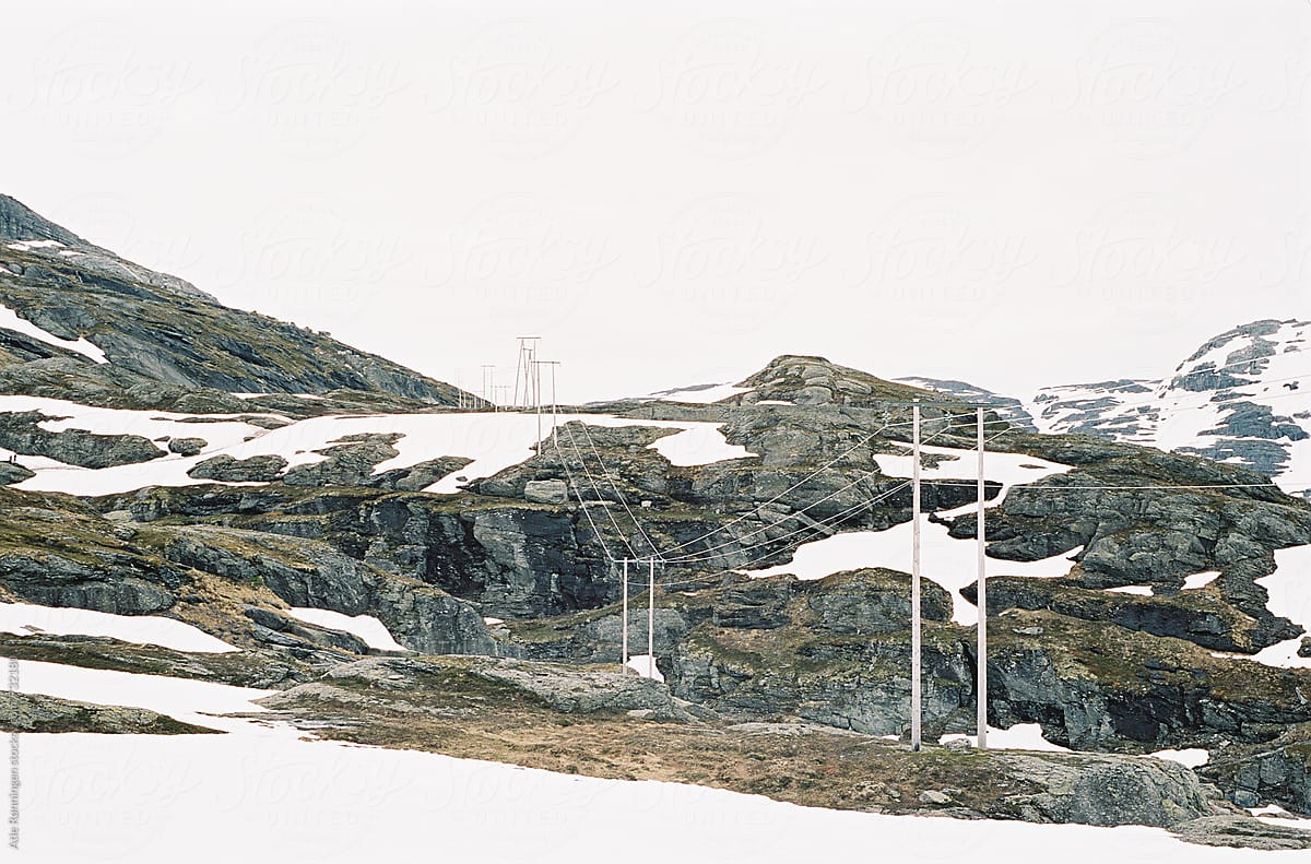 Power cords trough the Norwegian mountain landscape in snowy July