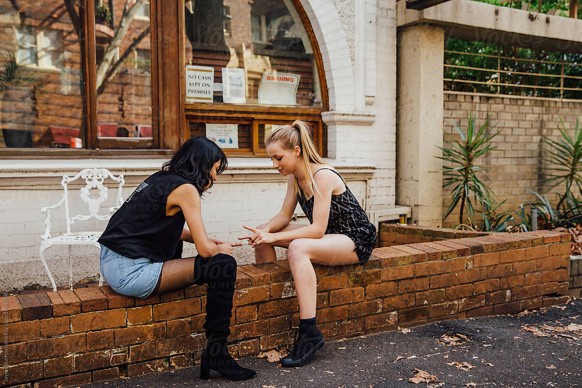Two Young Women Sit On A Brick Wall By Stocksy Contributor Jayme