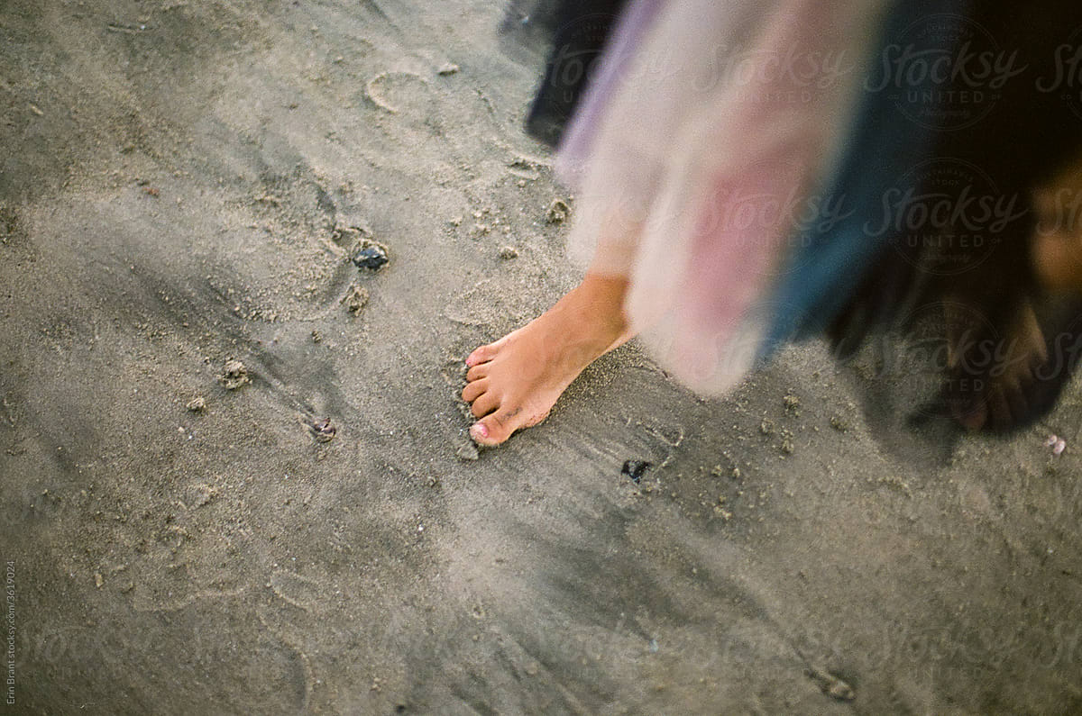 Bare foot of girl standing on beach