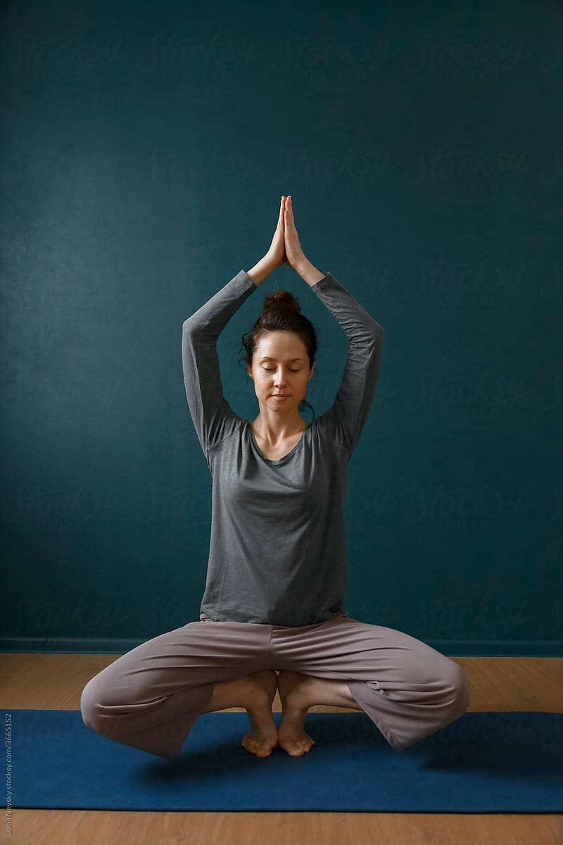 Female balancing and meditating in yoga studio