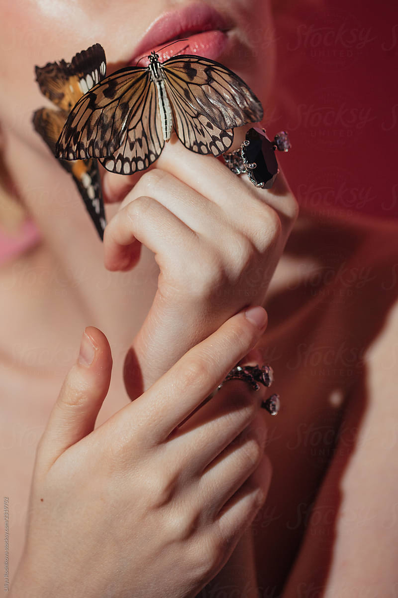 Closeup shot of unrecognizable woman\'s delicate hands and butterflies