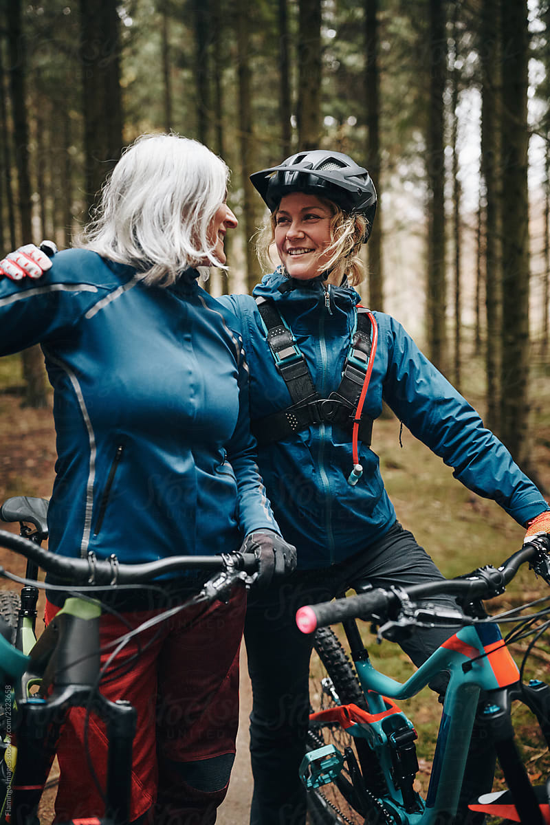 Smiling mother and daughter preparing to go mountain biking toge