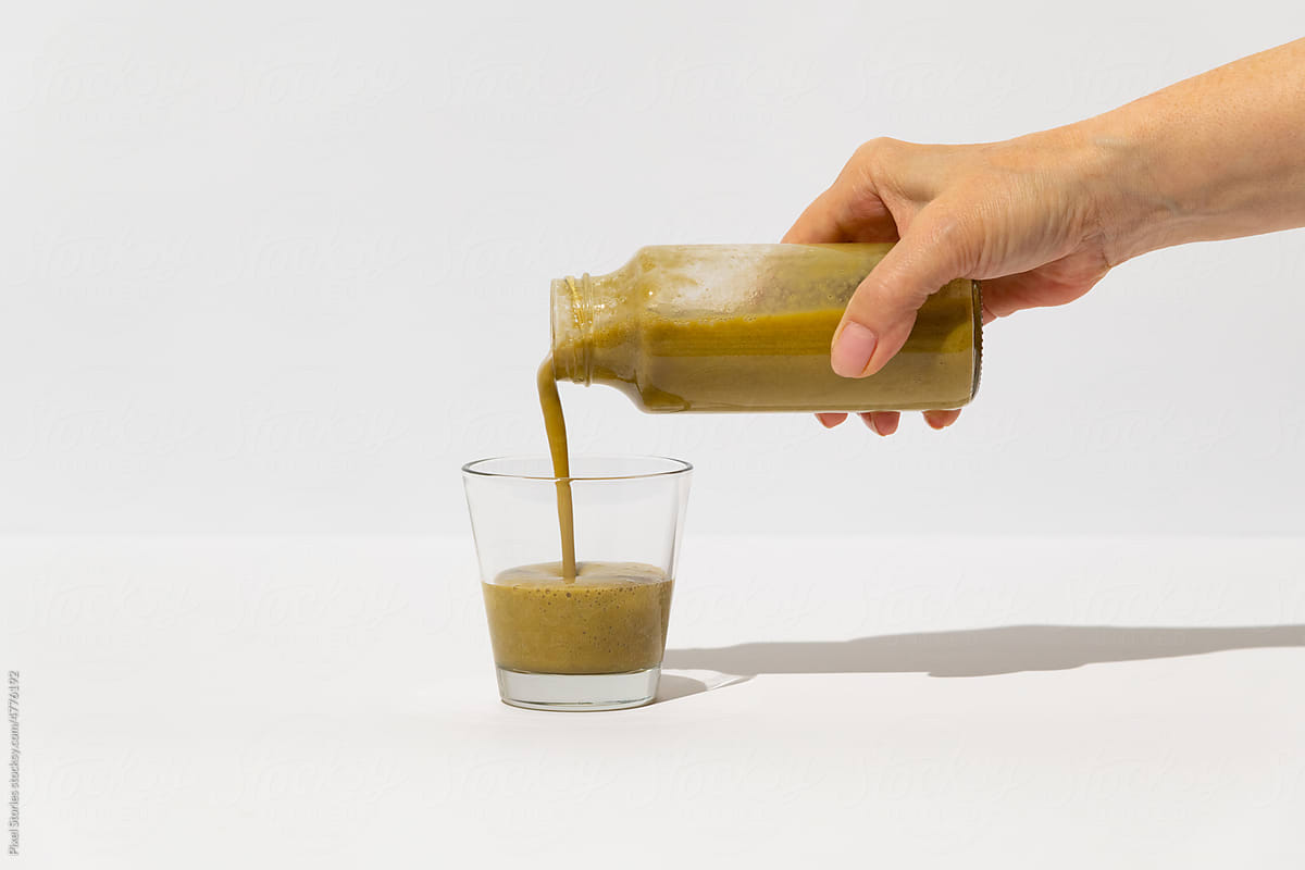 Woman poruing Chinese matcha healthy superfood drink into glass