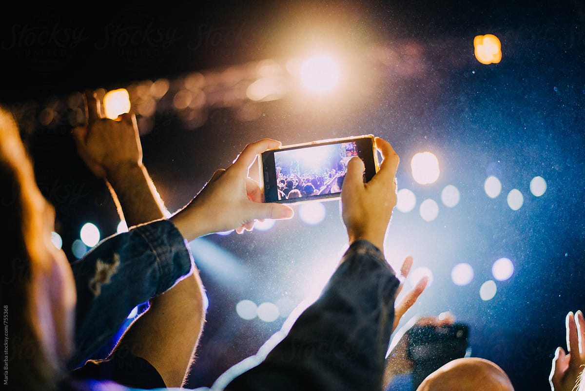 Taking a picture from the crowd with an smartphone in a music show