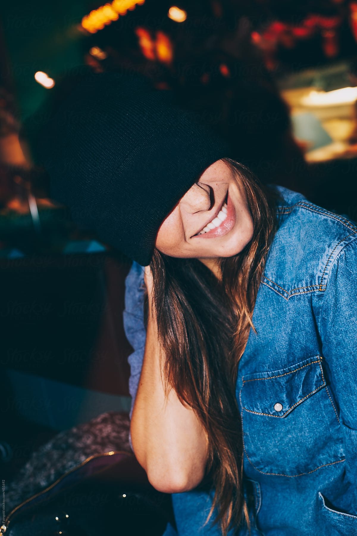 Girl in bar hiding face with hat