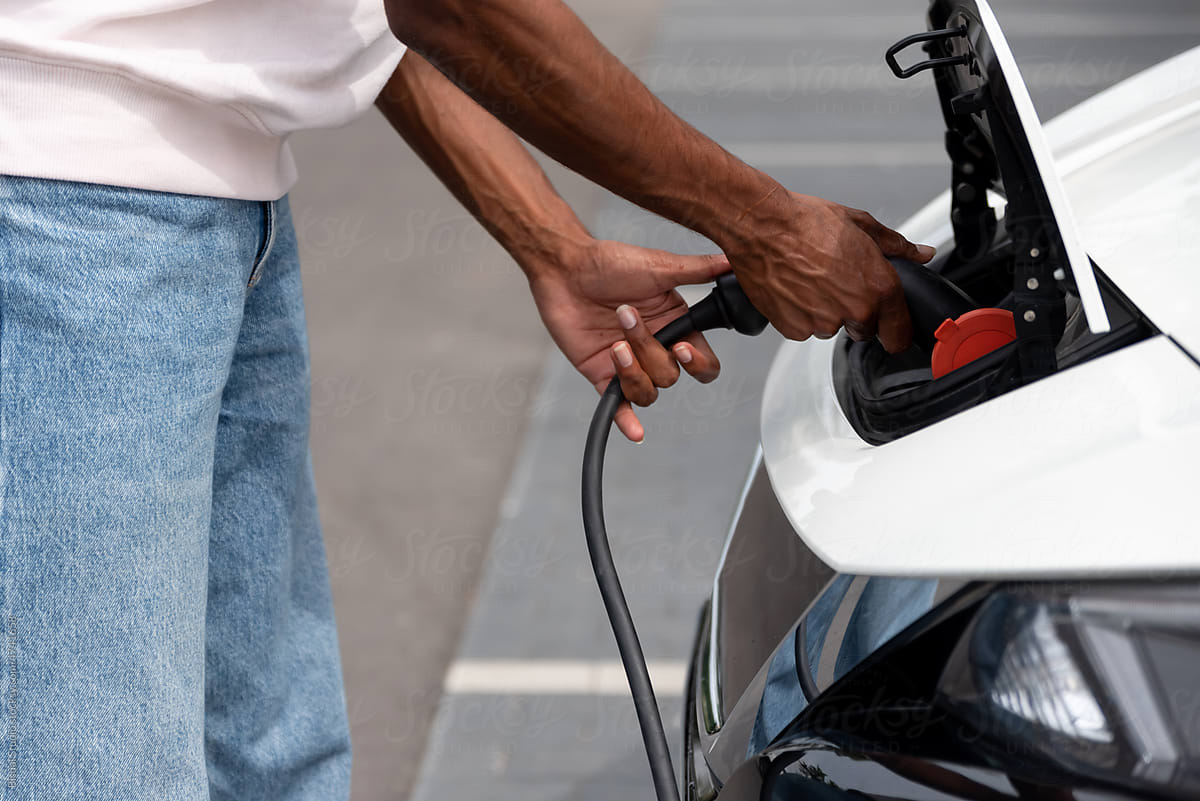 Anonymous black man charging an electric car