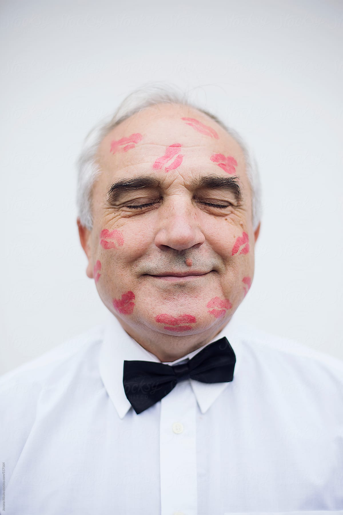 Portrait of an old man with red lip print on his face