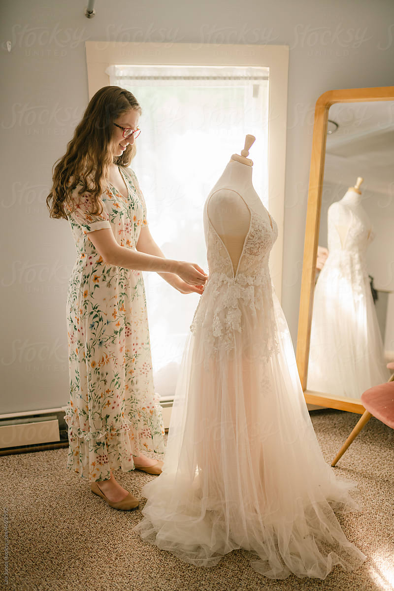 seamstress adjusting a wedding dress