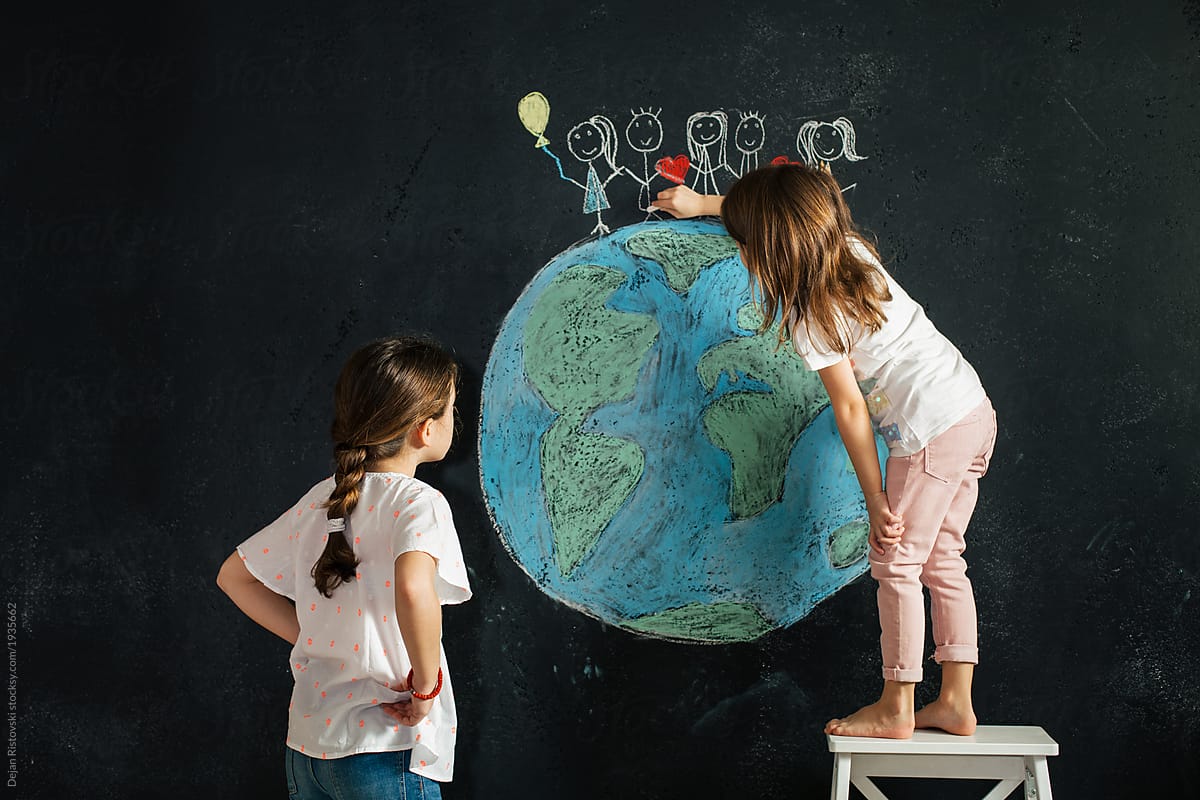 Young girl\'s  drawing planet earth on a blackboard
