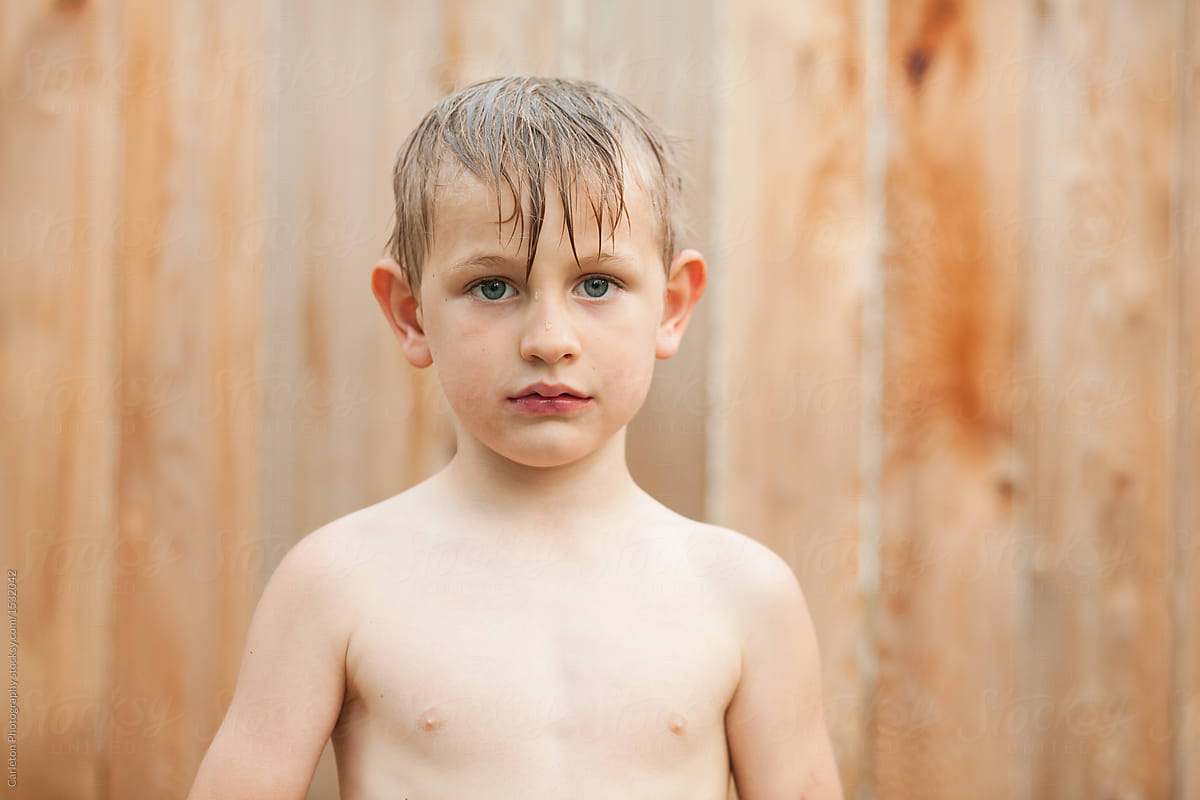 Shirtless boy takes a break from a water balloon fight to question life\'s meaning