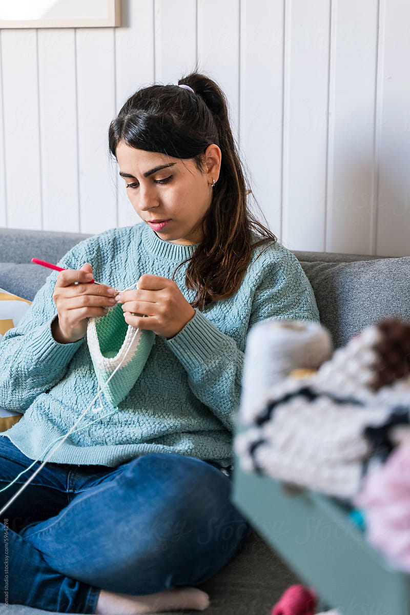 Young woman enjoying knitting at home