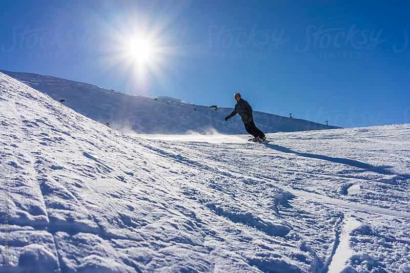 A man snowboarding at ski area