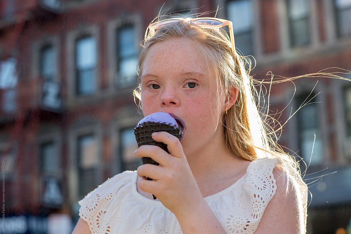 Teenager eating ice cream in an urban environment.