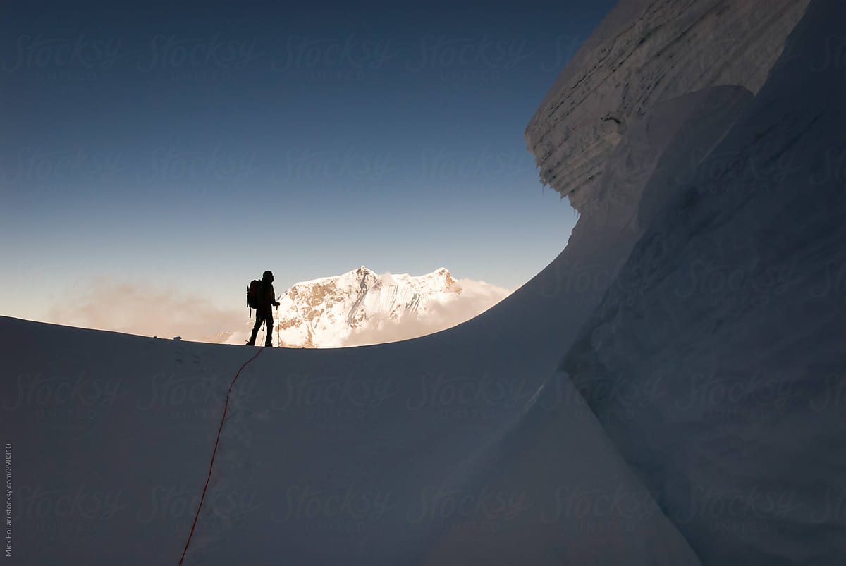 Silhouette of high altitude mountain climber on snow