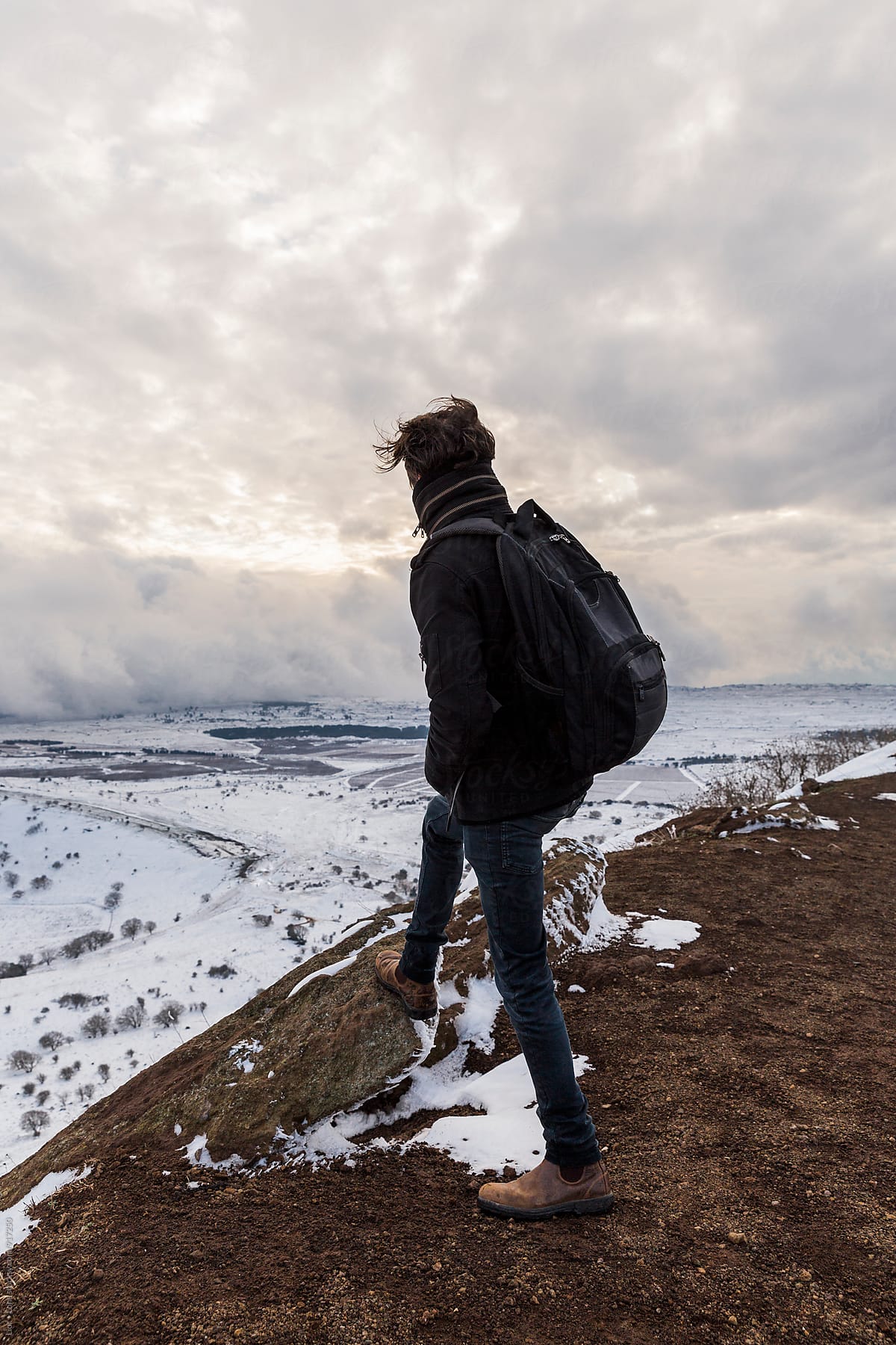 Man looking at winter landscape from the top of a mountain