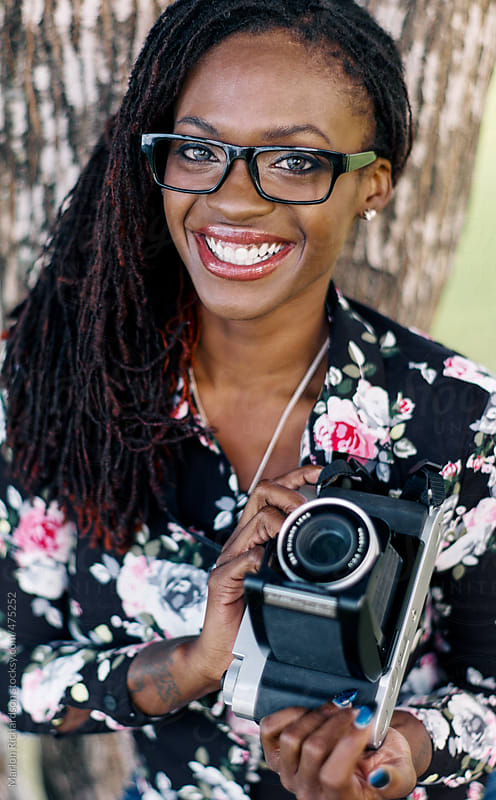 African American Female Hipster holding a vintage camera