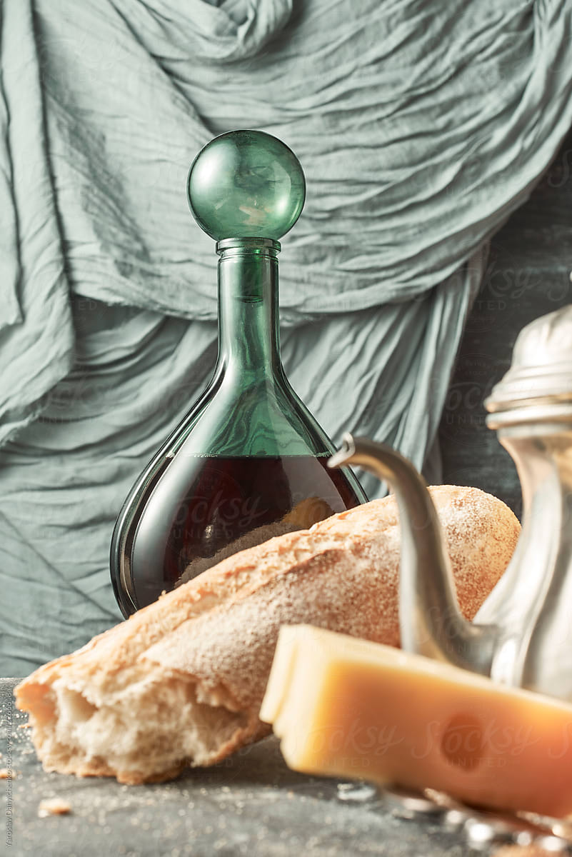 Closeup of homemade baguette, cheese wine in a decanter and a me