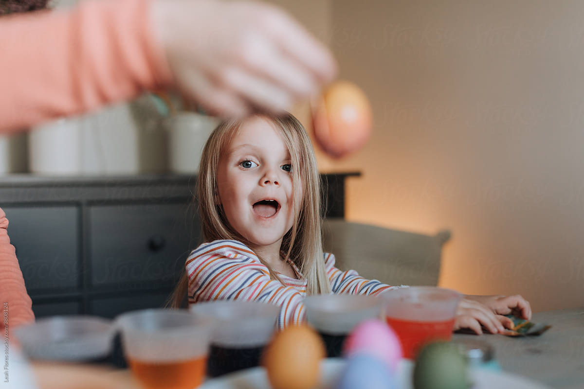 Adorable Blonde Girl Dyeing Easter Eggs