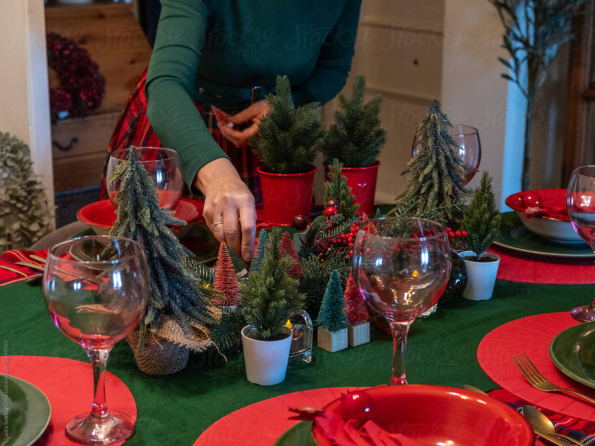 Woman setting a table for a Christmas dinner party