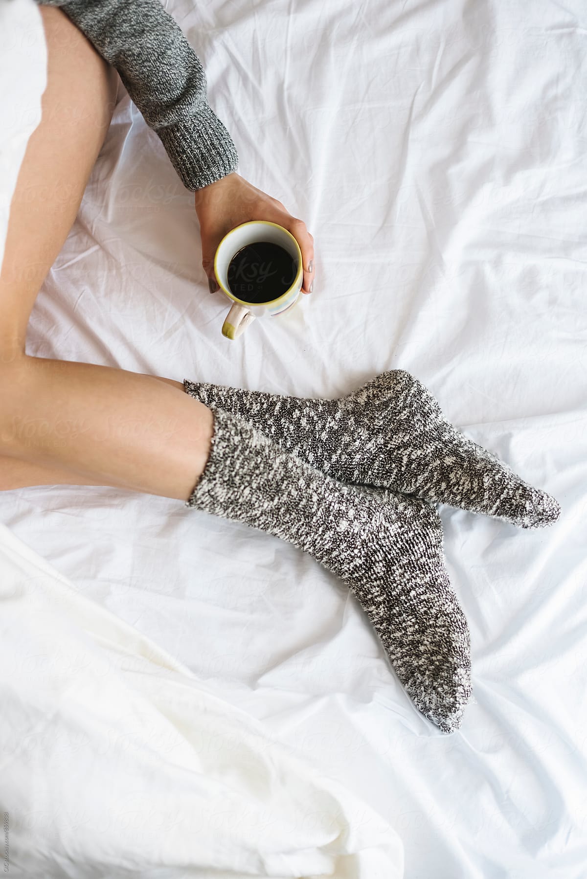 Woman holding a coffee mug in the bed