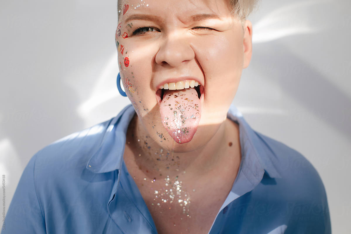 Funny portrait of woman showing sparkly tongue