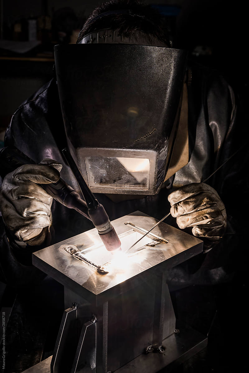 Man welds aluminum in his workplace