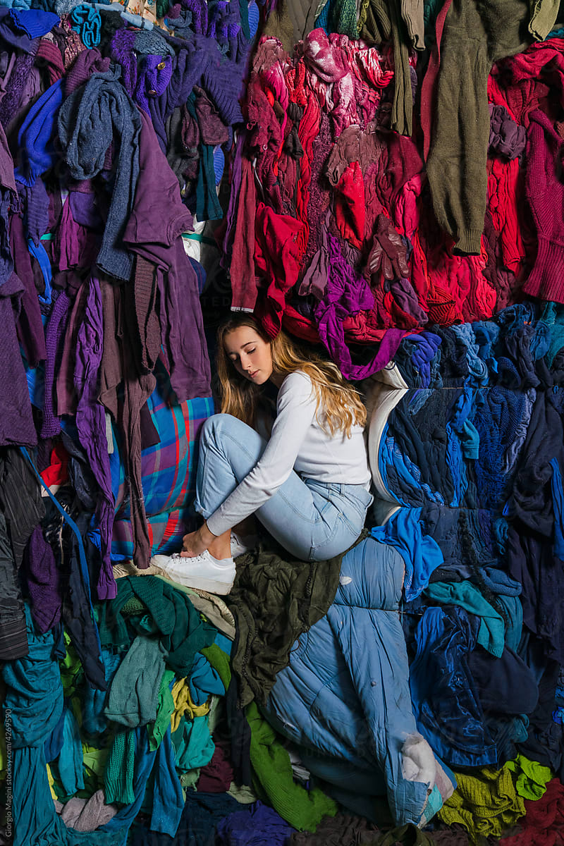 Young Woman Surrounded by Used Clothes