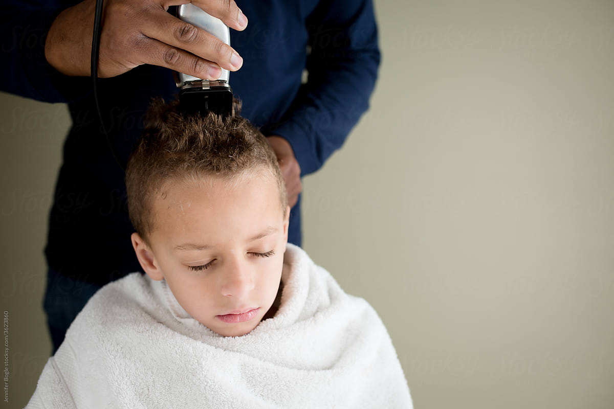 Boy with eyes closed getting home haircut