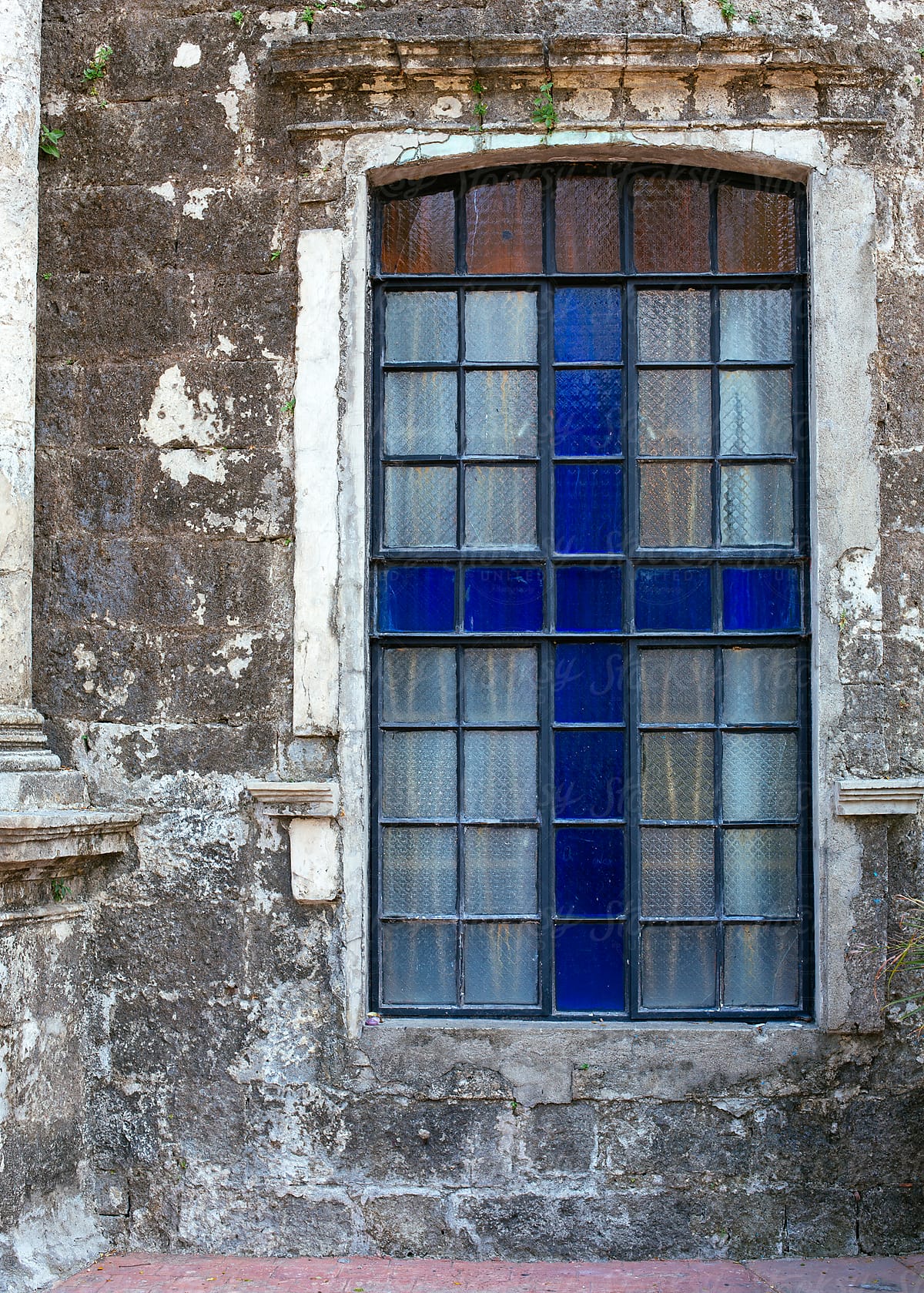 Window with blue cross design on a very old church