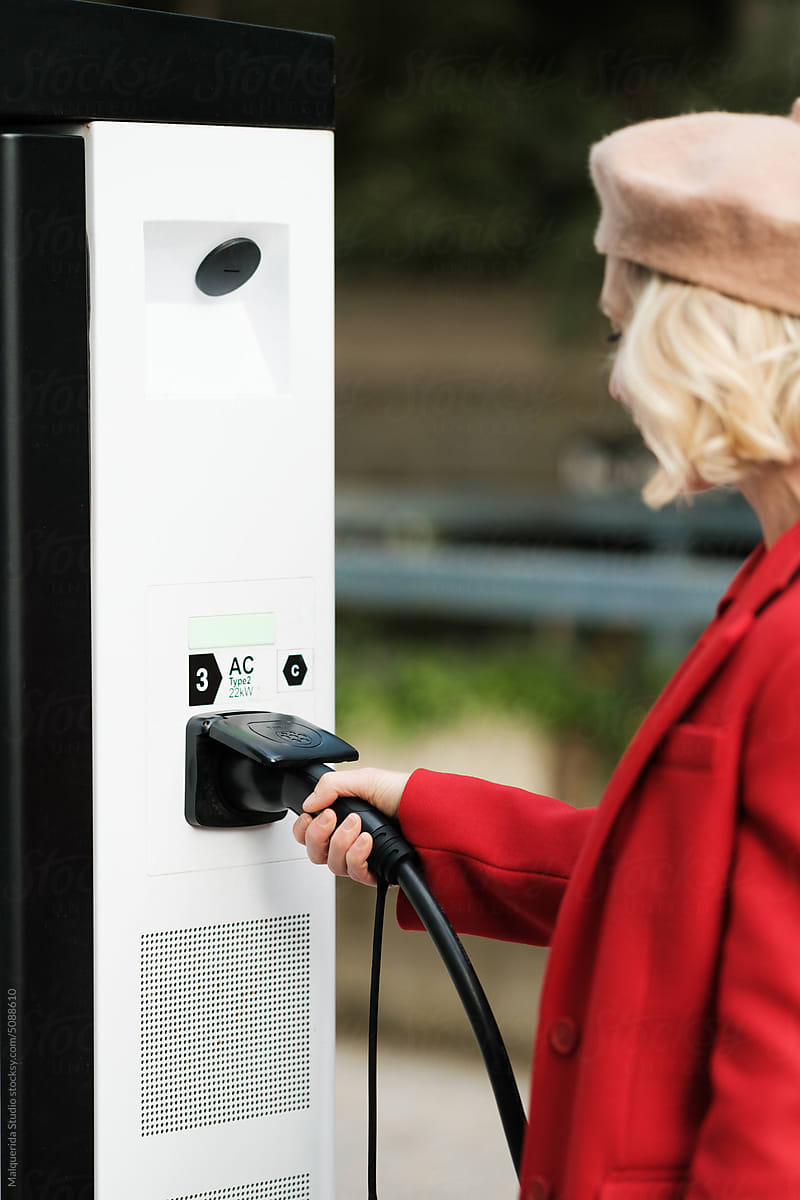 Woman recharge Electric Car on Charge Station