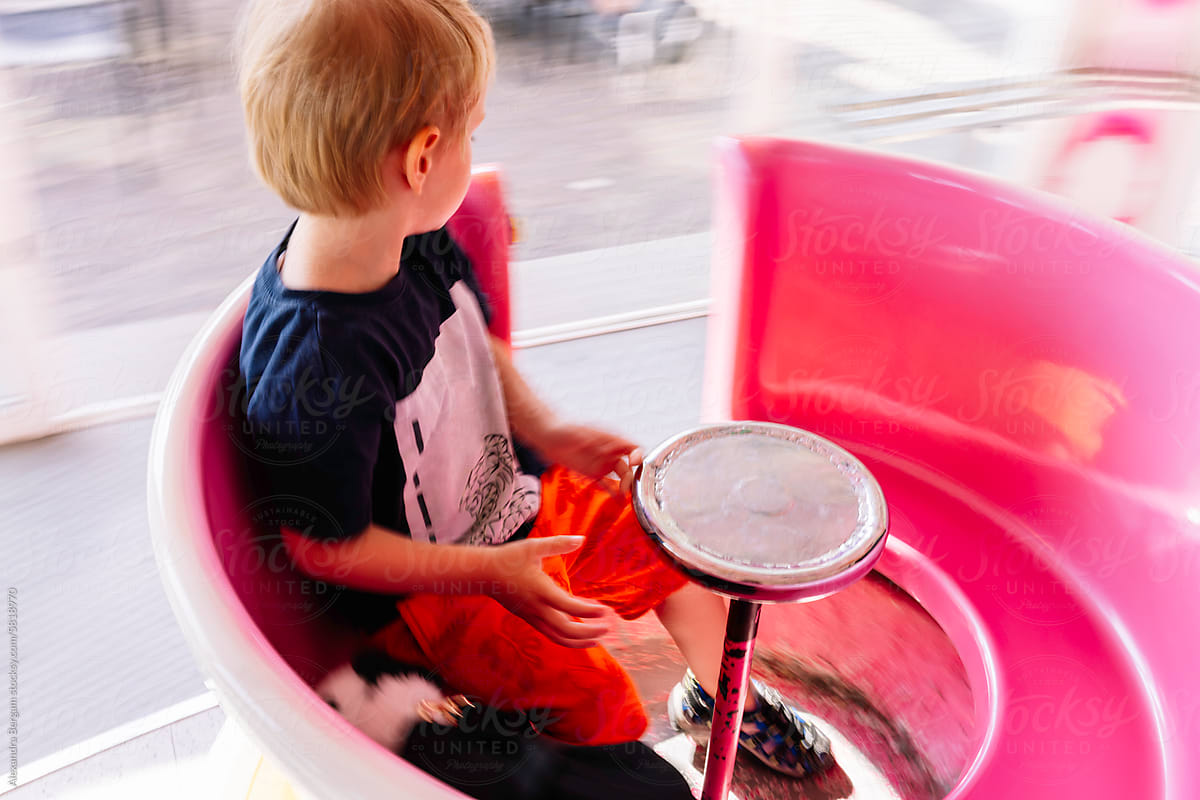 Child sits in a rotating basket in the carousel
