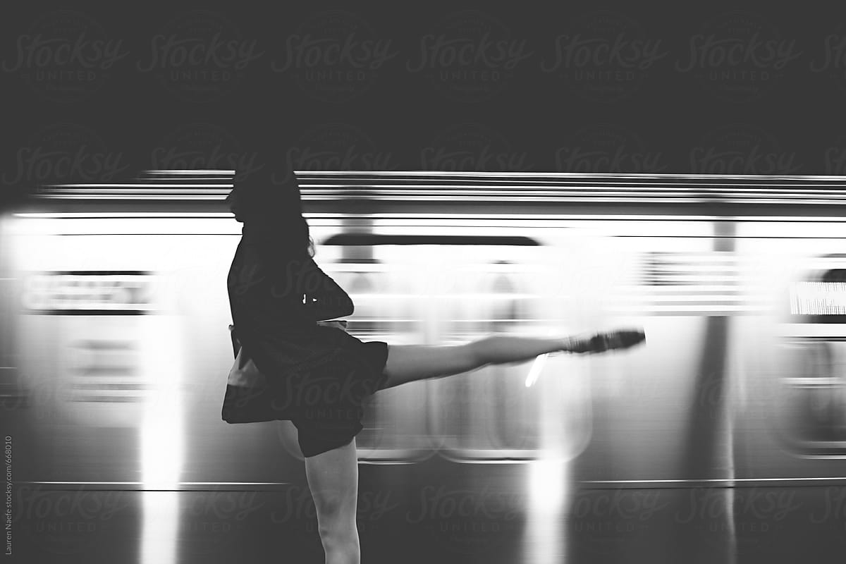 Silhouette dancing in front of moving train