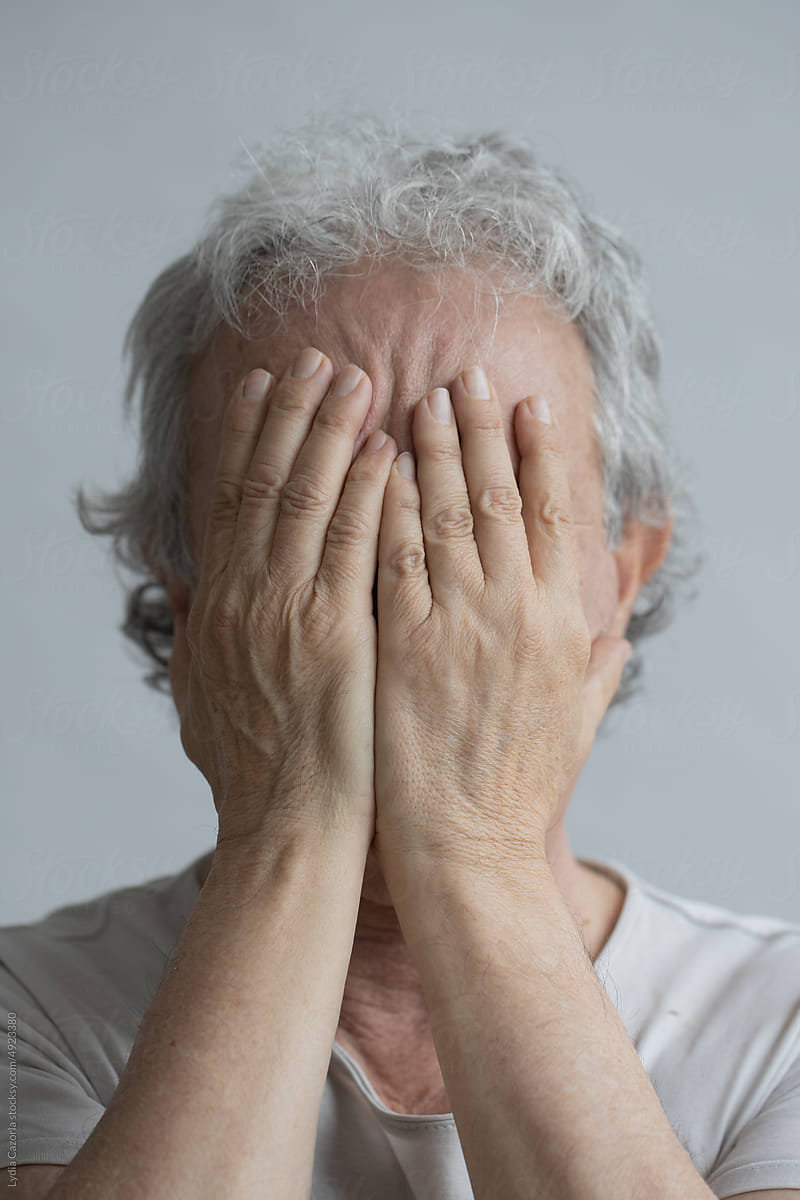 Middle-aged man covering his face